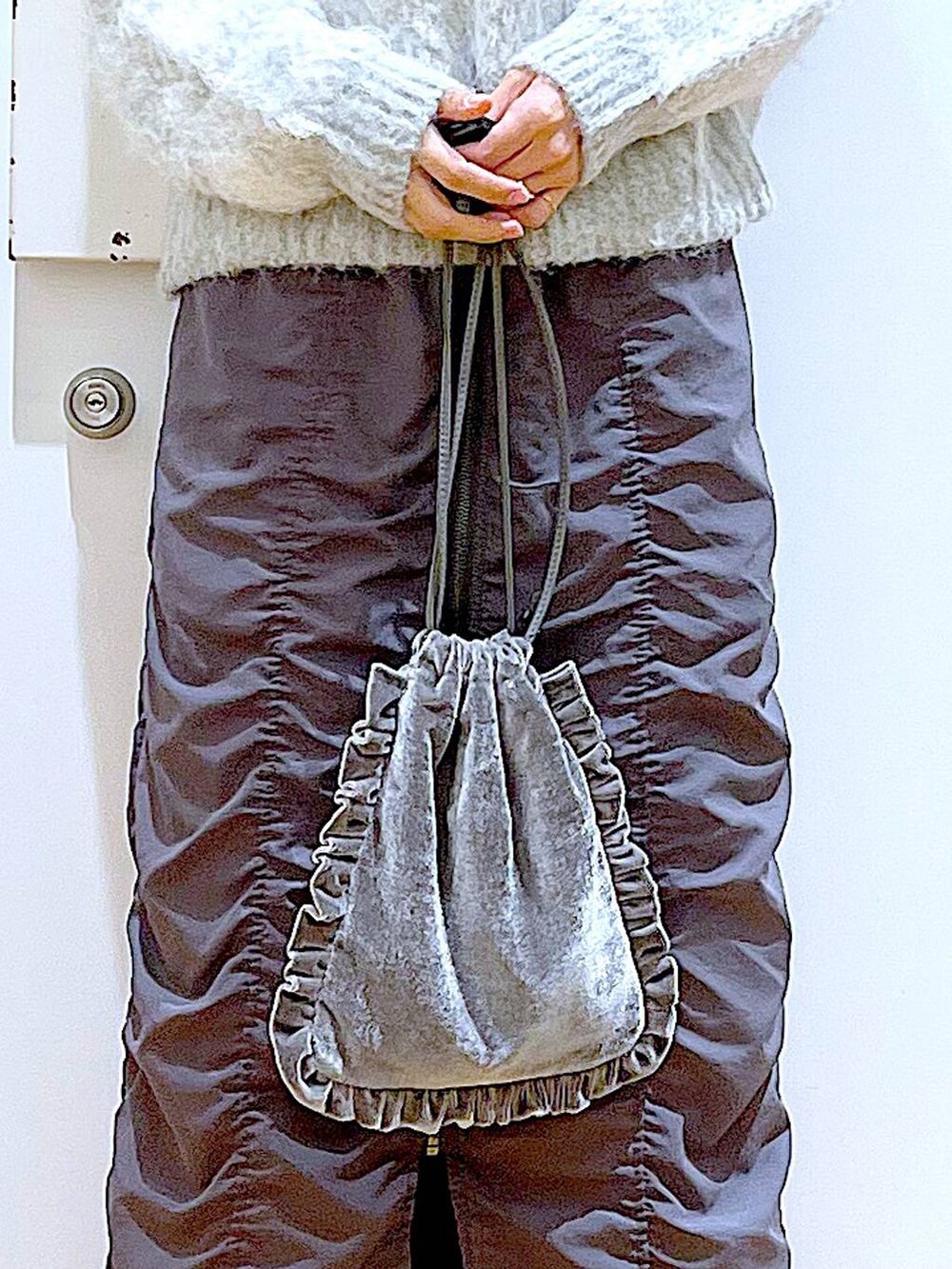 グレー系のショルダーバッグ、グレー系のスカート、ブラック系のブーツを着用したレディースの冬コーディネートの9枚目の写真