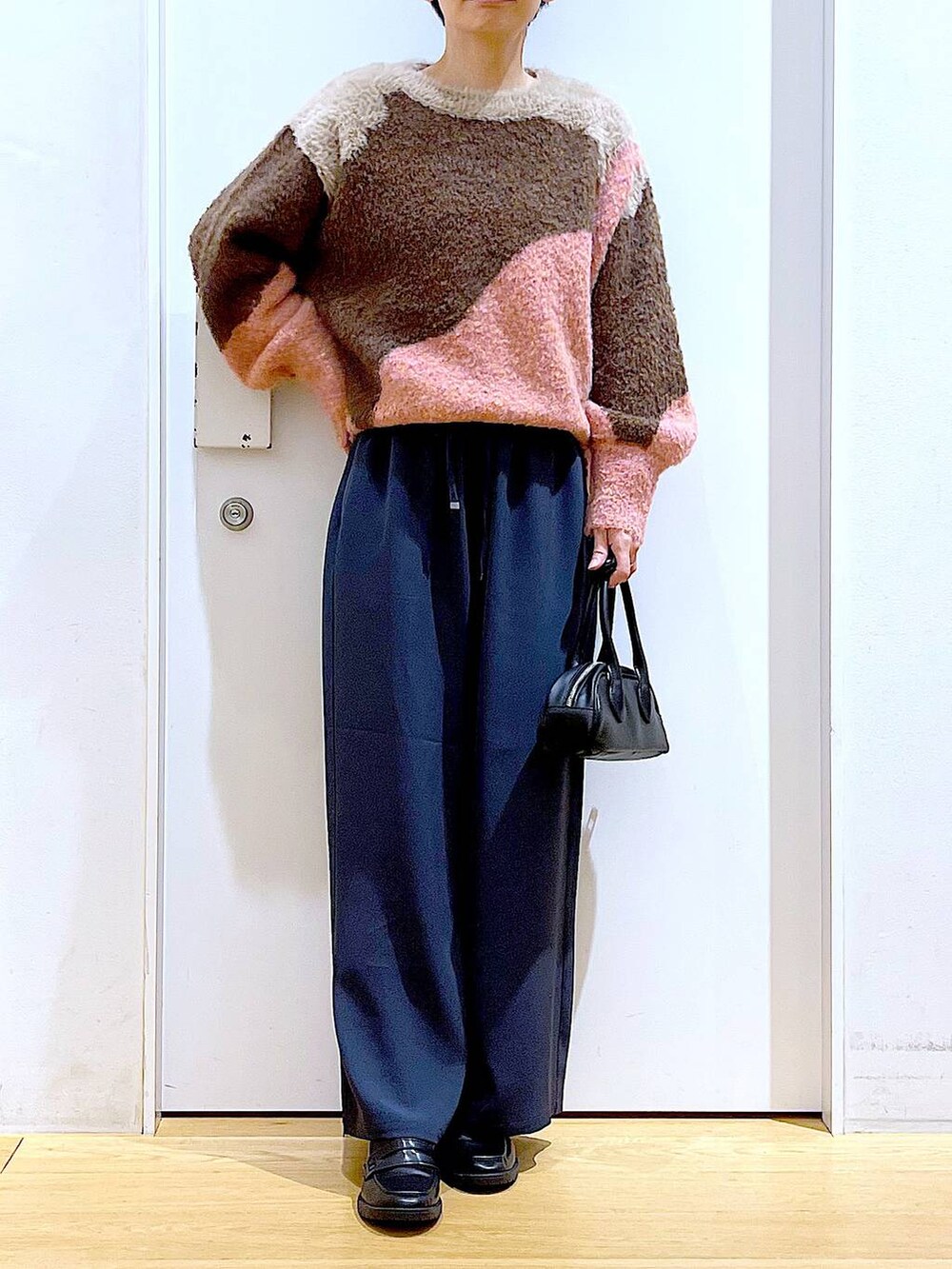 ブラック系のローファー、ピンク系のニット/セーター、ブラック系のボストンバッグを着用したレディースの冬コーディネートの6枚目の写真