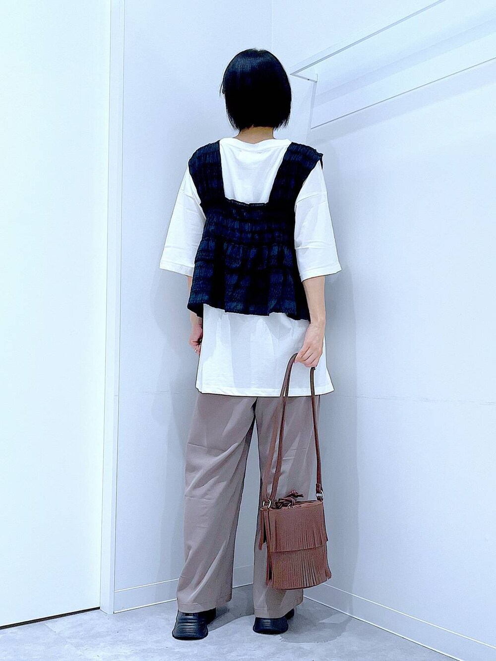 ブラック系のローファー、ブラウン系のショルダーバッグ、ブラウン系のその他パンツを着用したレディースの秋コーディネートの5枚目の写真