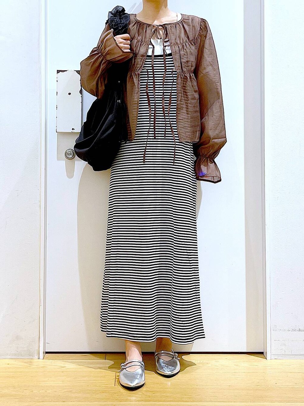 ブラック系のワンピース、シルバー系のパンプス、ブラック系のショルダーバッグを着用したレディースの夏コーディネートの6枚目の写真