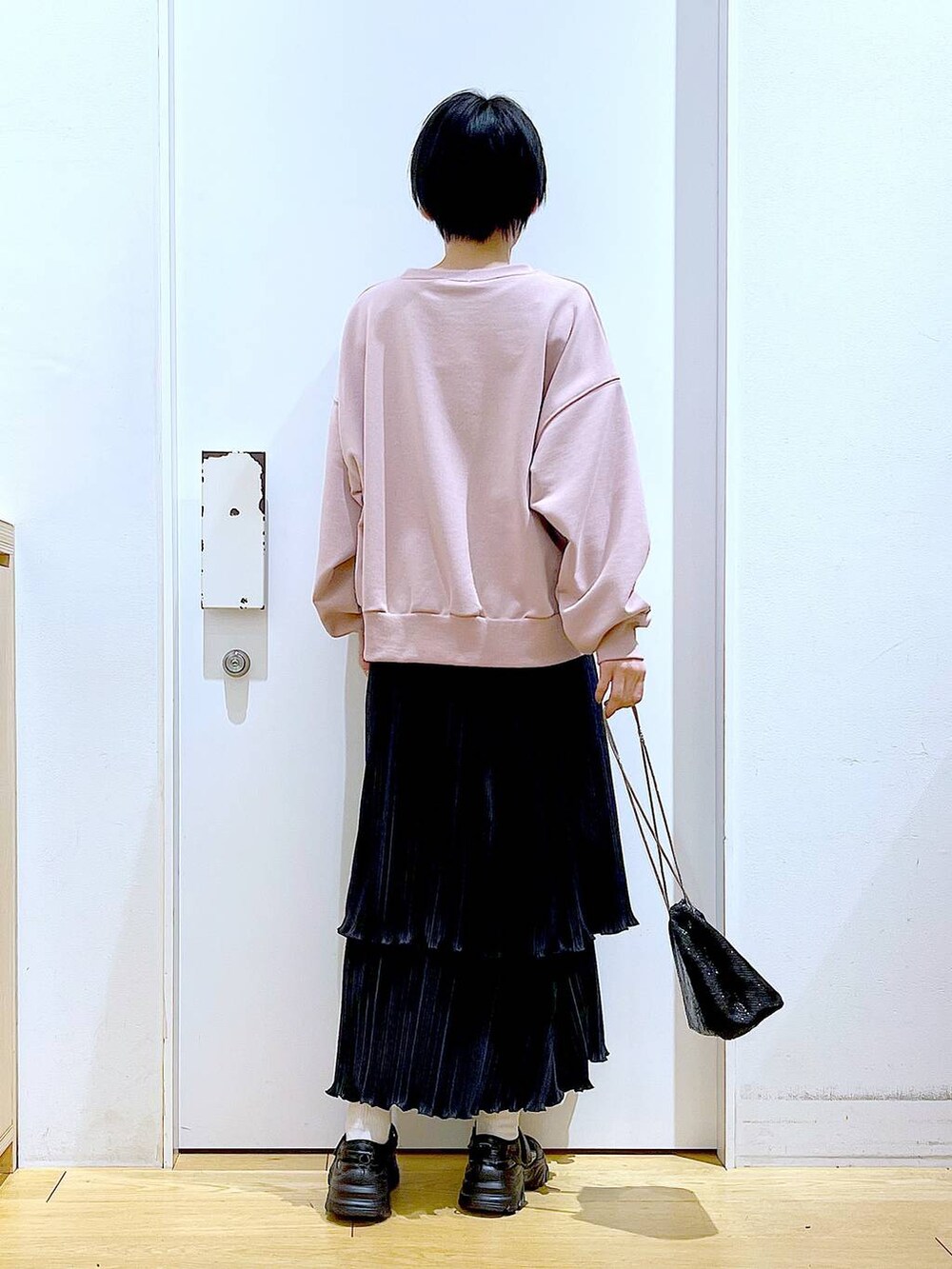 ブラック系のショルダーバッグ、ブラック系のスニーカー、ピンク系のスウェットを着用したレディースの春コーディネートの5枚目の写真