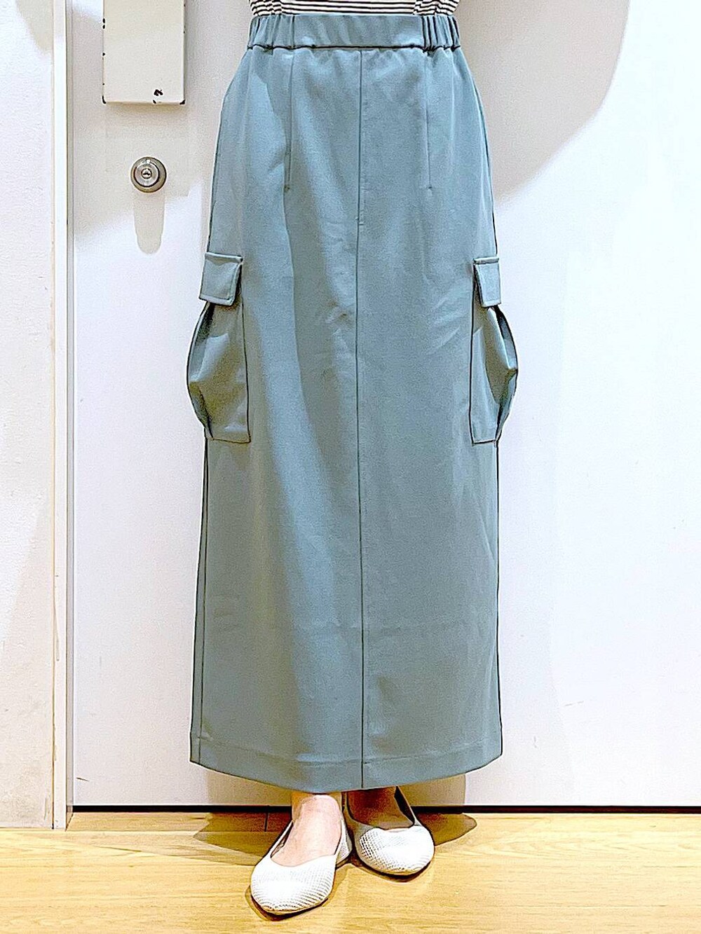 ホワイト系のショルダーバッグ、ホワイト系のパンプス、グリーン系のスカートを着用したレディースの春コーディネートの8枚目の写真