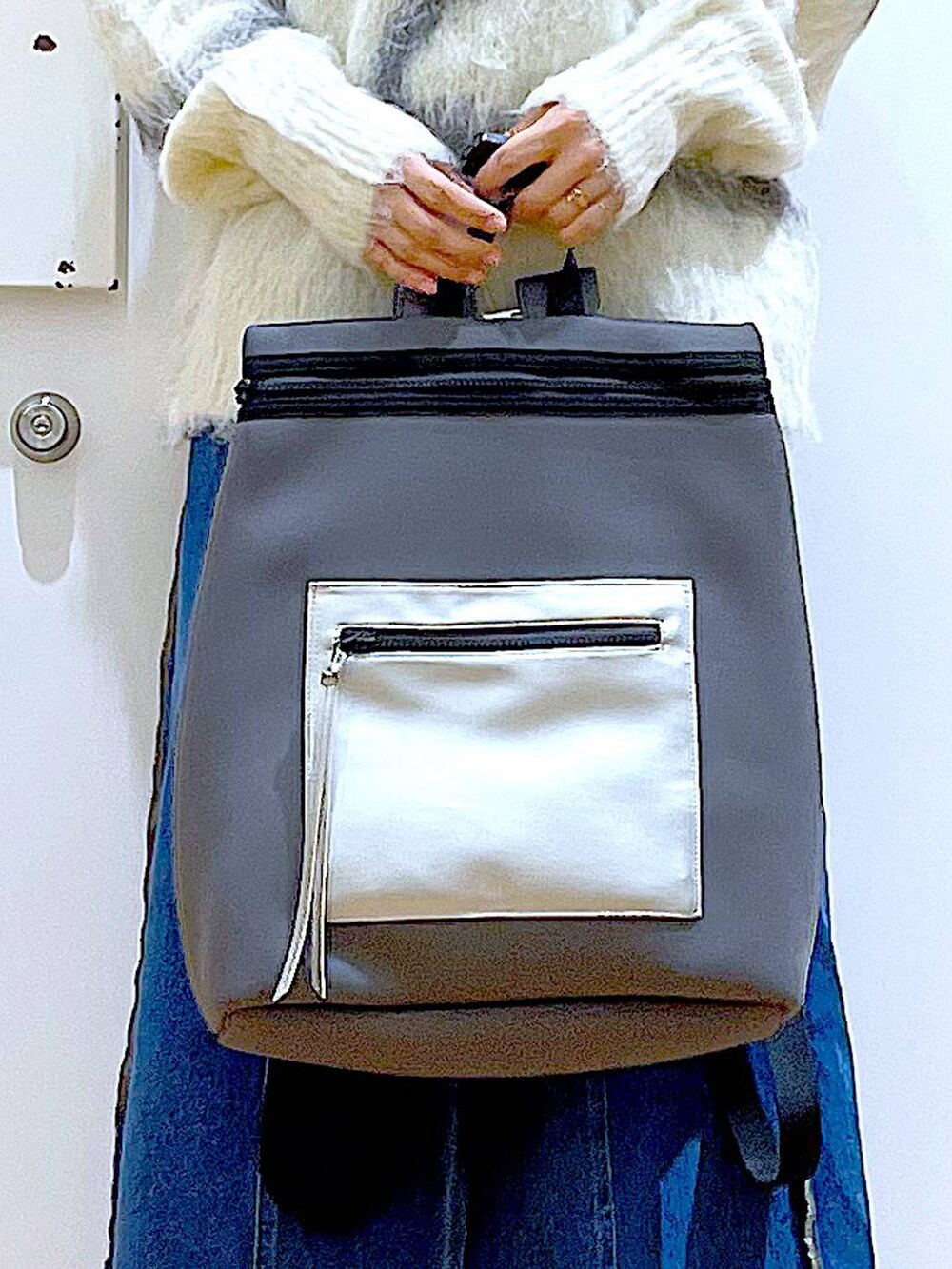 ホワイト系のニット/セーター、グレー系のバックパック/リュック、ブルー系のデニムスカートを着用したレディースの冬コーディネートの9枚目の写真