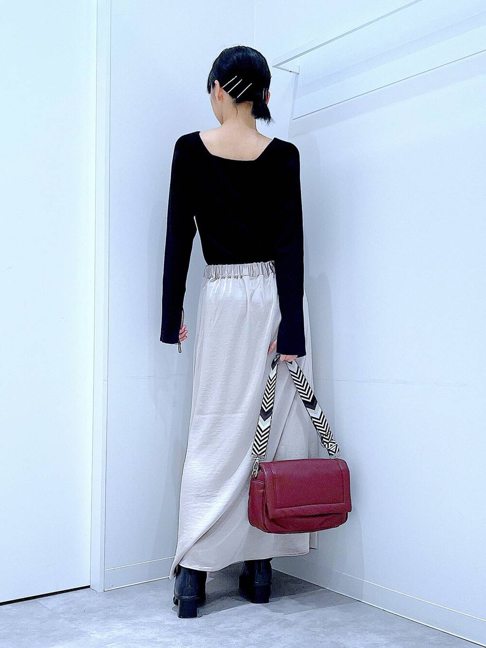 ブラック系のニット/セーター、ベージュ系のスカート、レッド系のショルダーバッグを着用したレディースの秋コーディネートの5枚目の写真