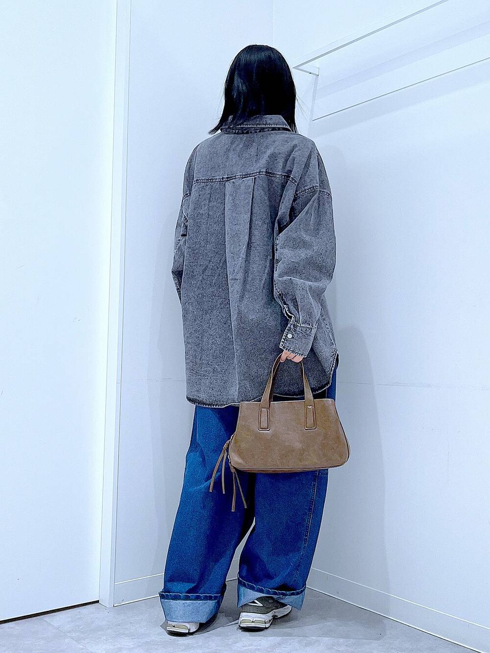 ブラウン系のボストンバッグ、ブルー系のデニムパンツ、ブラック系のシャツ/ブラウスを着用したレディースの冬コーディネートの5枚目の写真