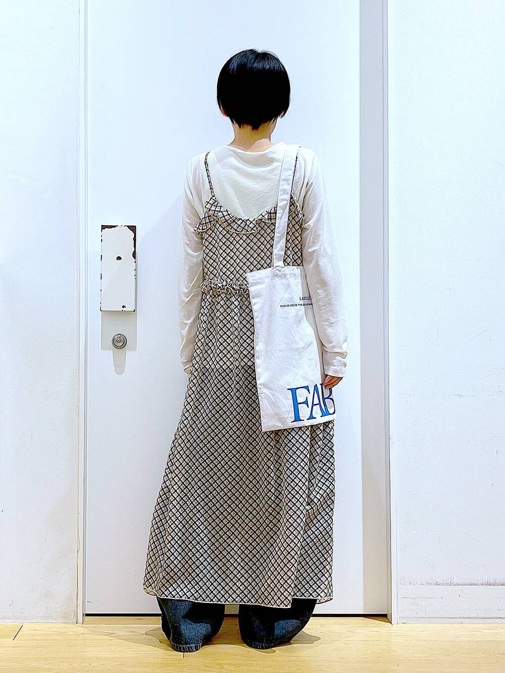 ブルー系のデニムパンツ、シルバー系のパンプス、ホワイト系のTシャツ/カットソーを着用したレディースの春コーディネートの5枚目の写真