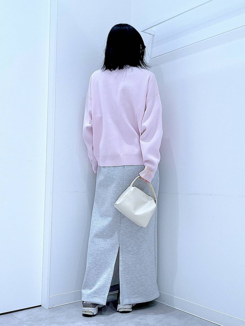 ホワイト系のショルダーバッグ、ピンク系のニット/セーター、グレー系のスカートを着用したレディースの冬コーディネートの5枚目の写真