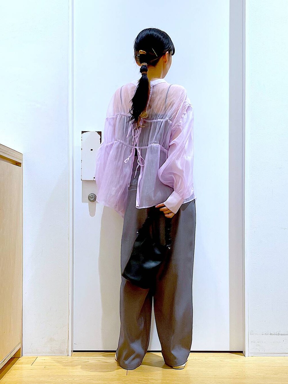 ブラック系のショルダーバッグ、パープル系のシャツ/ブラウス、ホワイト系のパンプスを着用したレディースの春コーディネートの5枚目の写真