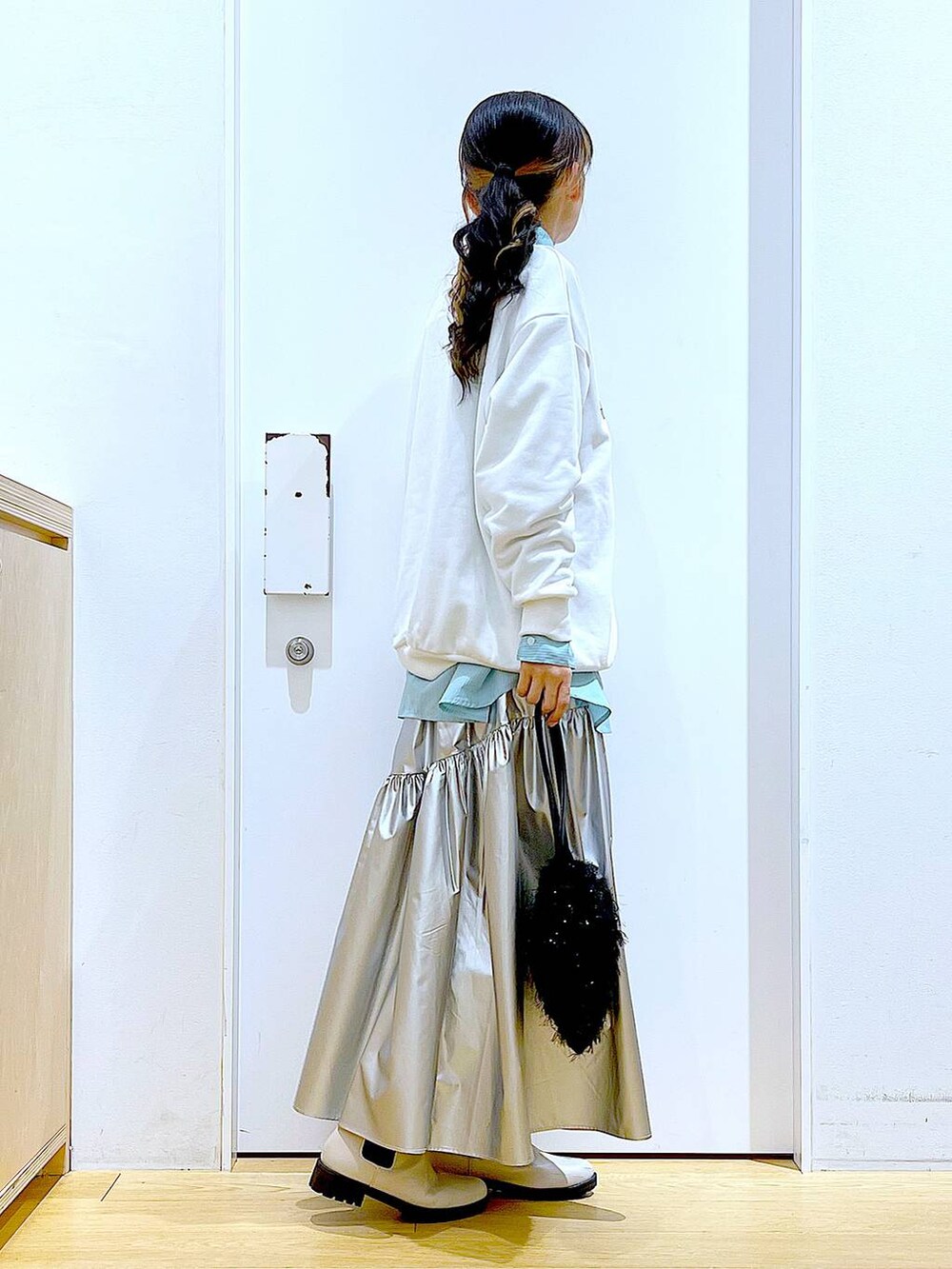 グリーン系のシャツ/ブラウス、シルバー系のスカート、ベージュ系のブーツを着用したレディースの春コーディネートの3枚目の写真