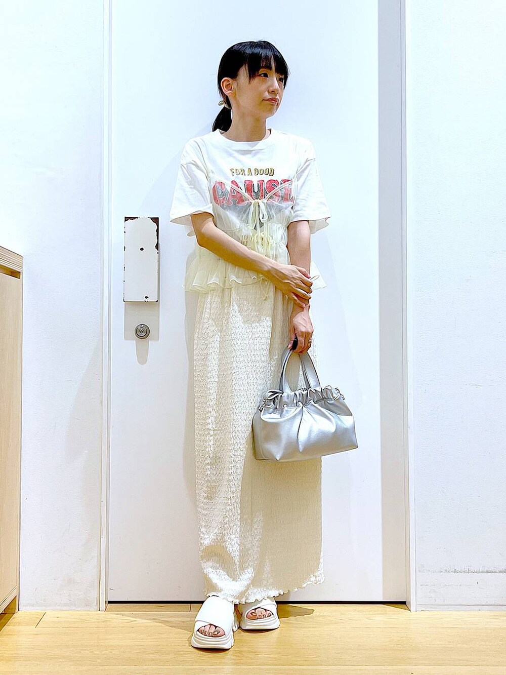 ホワイト系のサンダル、ホワイト系のTシャツ/カットソー、イエロー系のキャミソールを着用したレディースの夏コーディネートの2枚目の写真