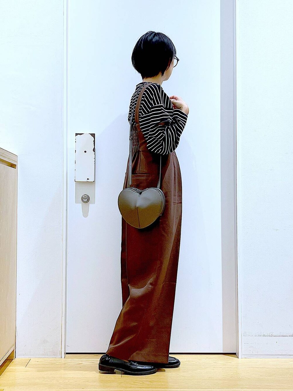 シルバー系のショルダーバッグ、ブラック系のローファー、ブラウン系のサロペット/オーバーオールを着用したレディースの秋コーディネートの4枚目の写真