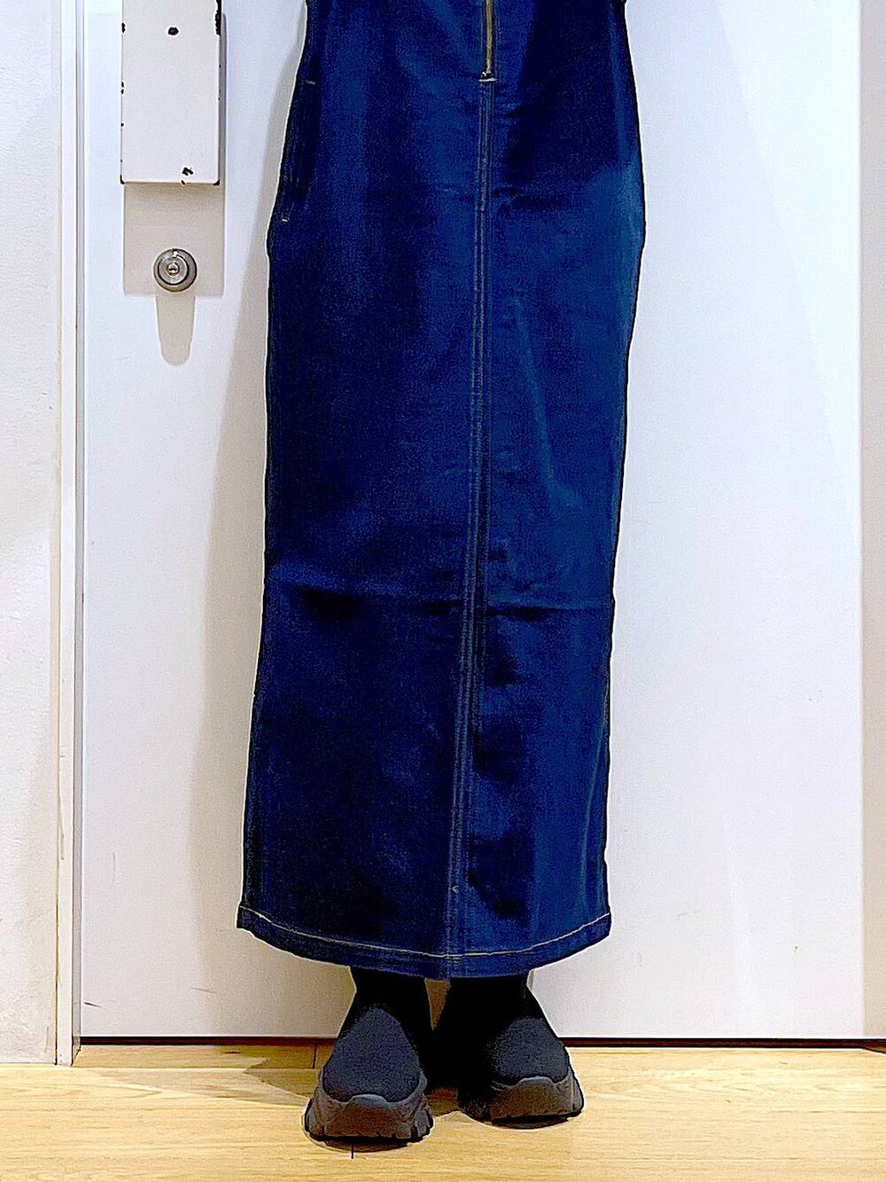 ブルー系のジャンパースカート、ブルー系のカーディガン/ボレロ、ブラック系のブーツを着用したレディースの春コーディネートの7枚目の写真