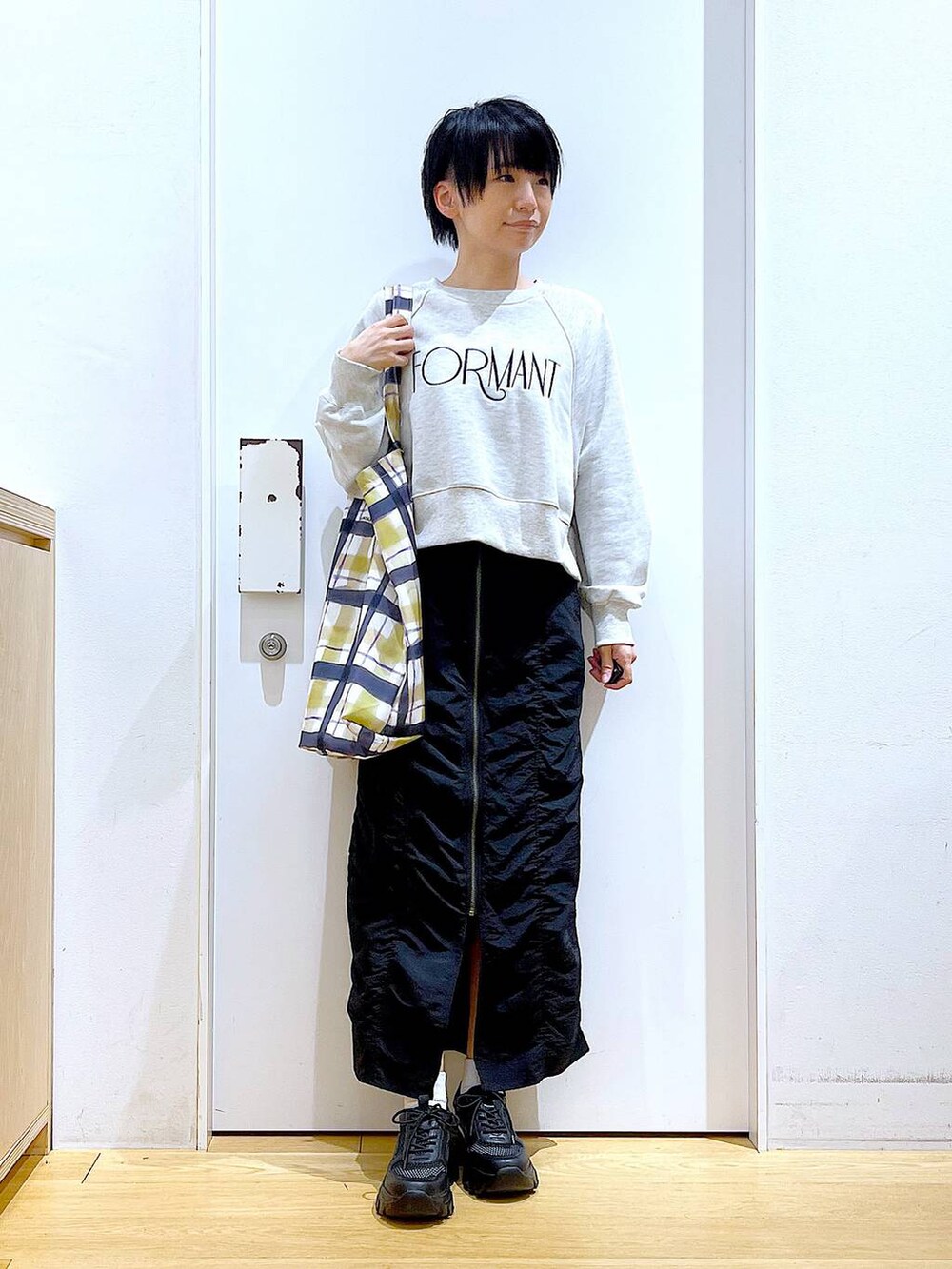 ブラック系のスカート、ブラック系のスニーカー、その他のトートバッグを着用したレディースの春コーディネートの2枚目の写真