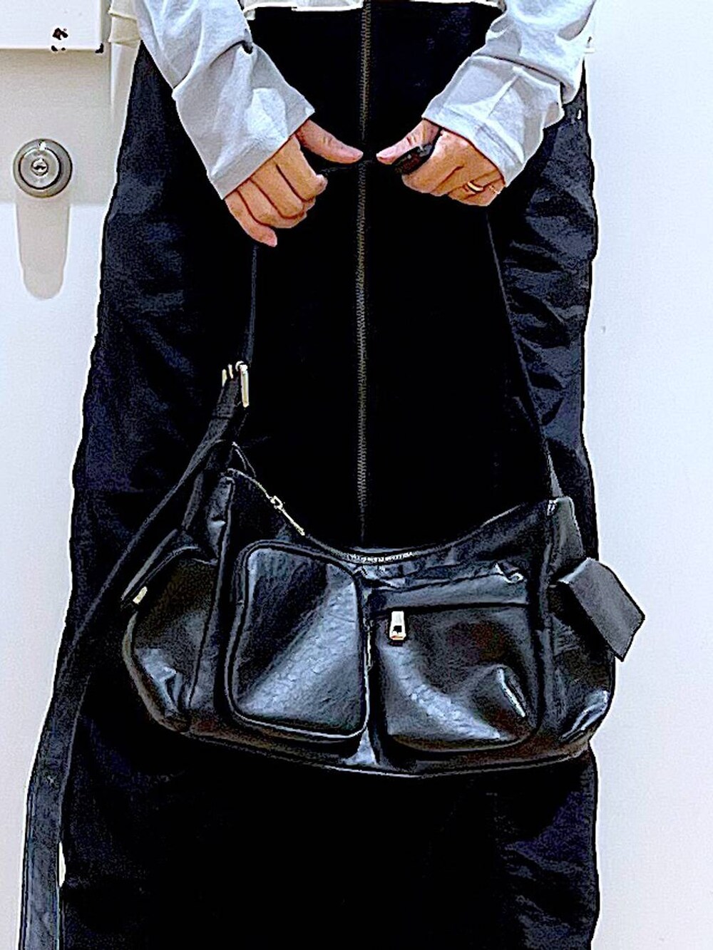 ブラック系のスカート、ブラック系のショルダーバッグ、ホワイト系のスニーカーを着用したレディースの春コーディネートの9枚目の写真