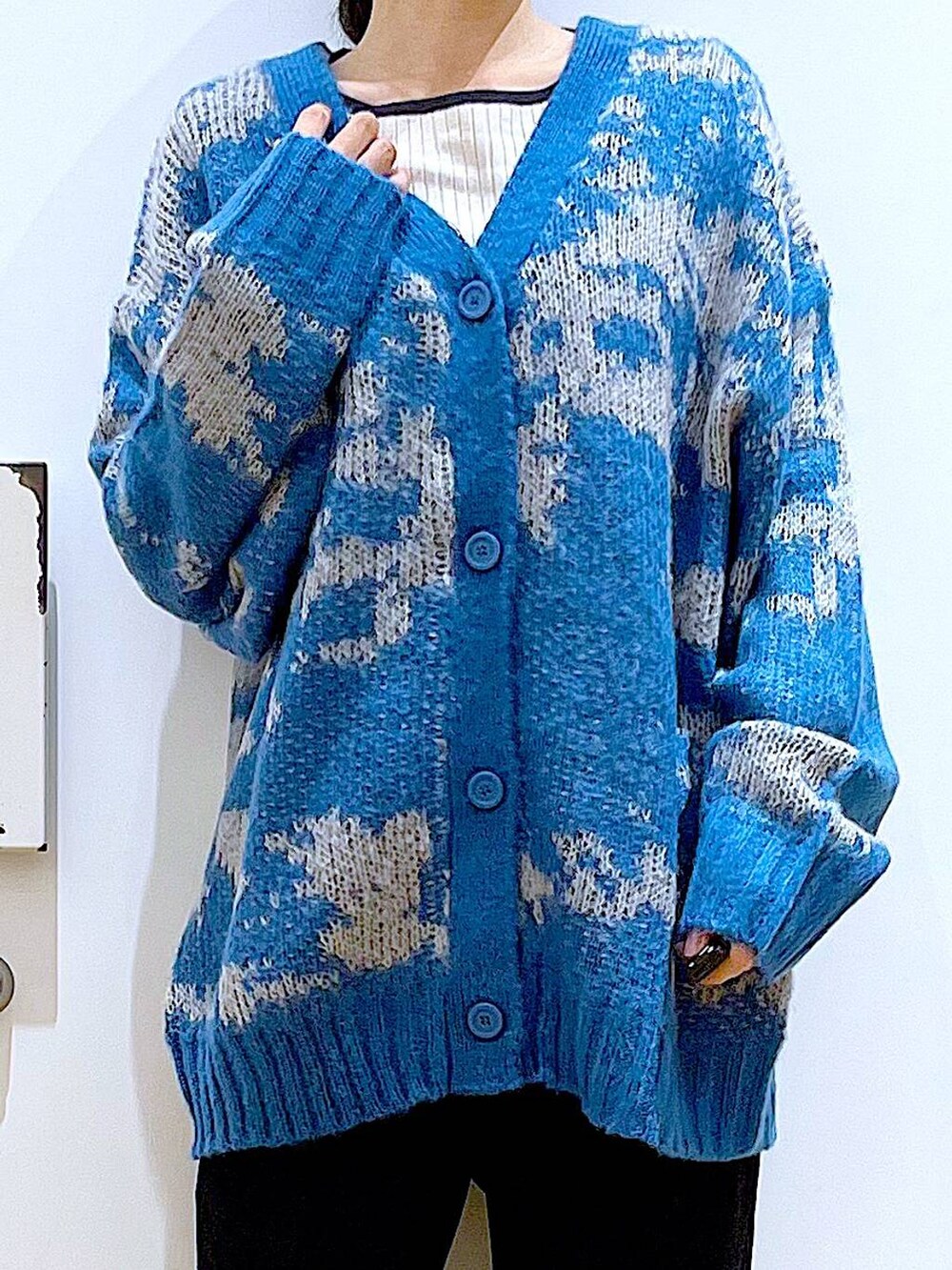 シルバー系のショルダーバッグ、ベージュ系のニット/セーター、ブラック系のブーツを着用したレディースの冬コーディネートの7枚目の写真