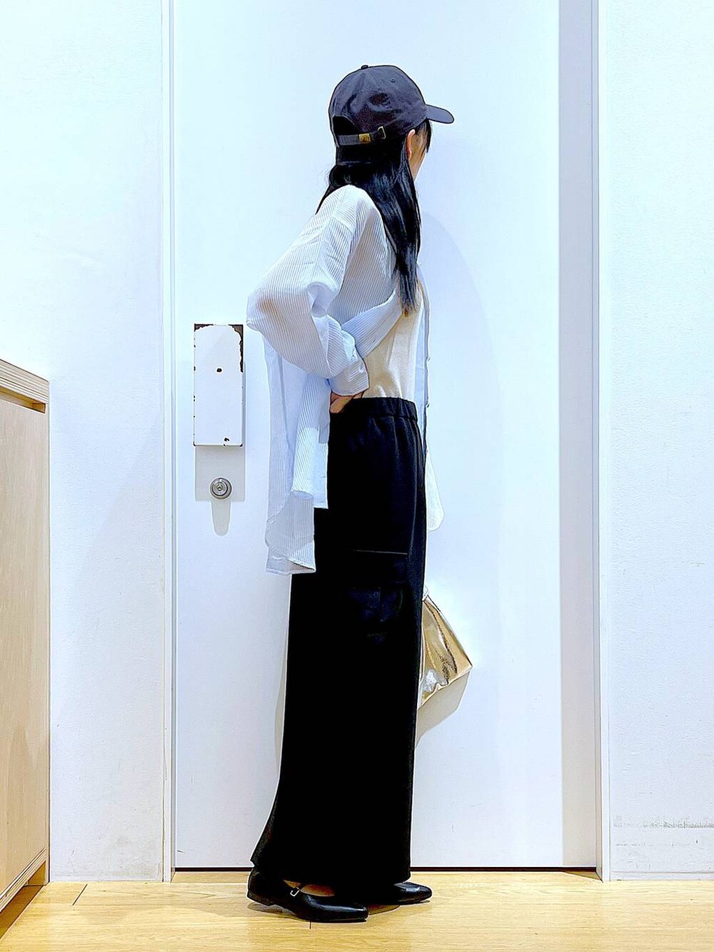 シルバー系のショルダーバッグ、ブラック系のパンプス、ブラック系のスカートを着用したレディースの春コーディネートの4枚目の写真