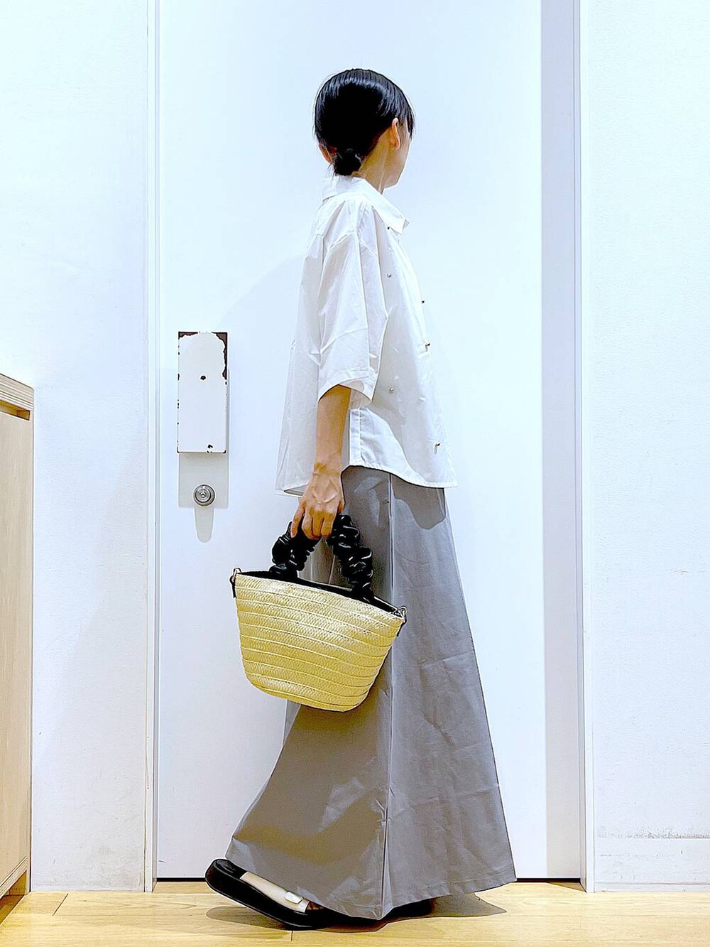 ホワイト系のサンダル、ホワイト系のショルダーバッグ、グレー系のスカートを着用したレディースの夏コーディネートの4枚目の写真