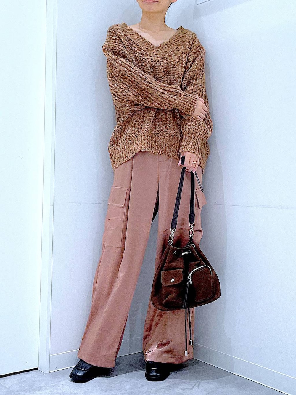 ブラウン系のニット/セーター、ブラウン系のショルダーバッグ、ブラック系のブーツを着用したレディースの冬コーディネートの6枚目の写真