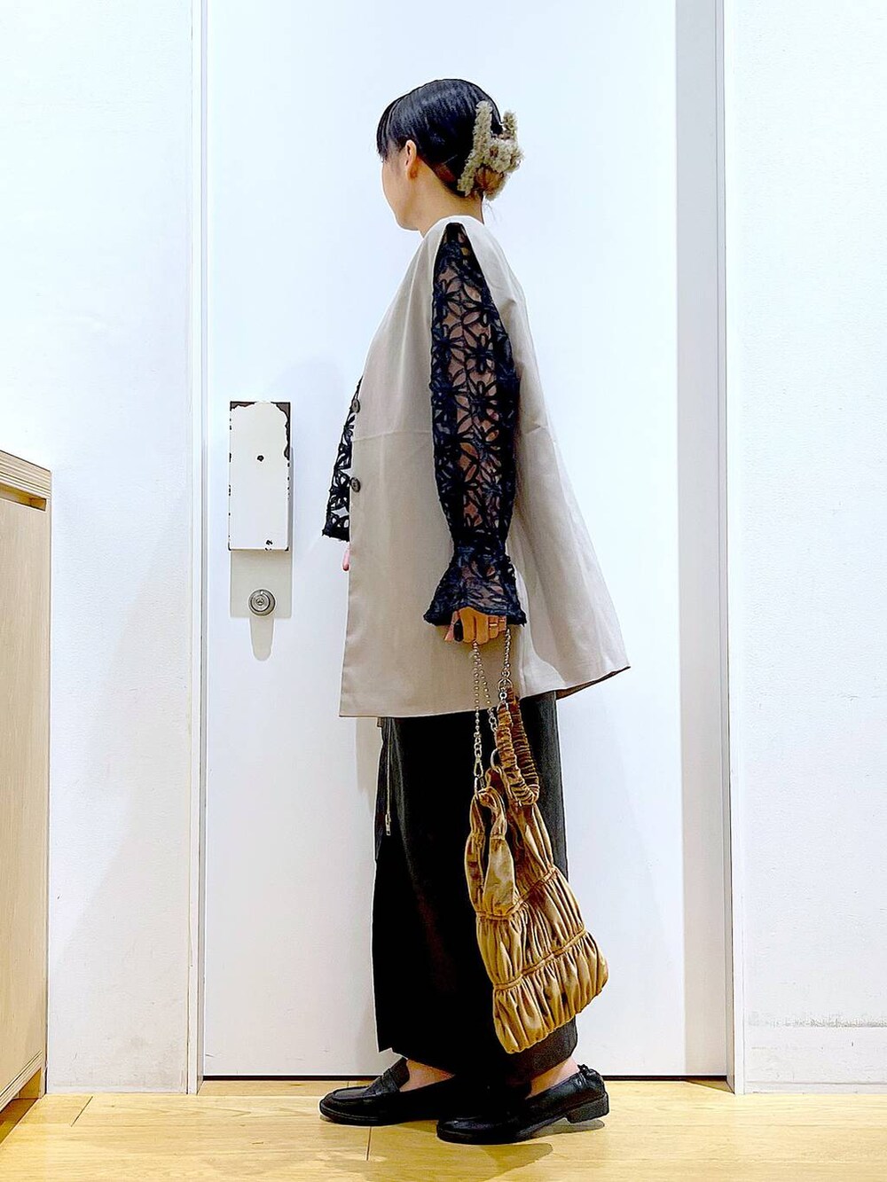 ブラック系のスカート、ブラック系のローファー、ベージュ系のベストを着用したレディースの秋コーディネートの3枚目の写真