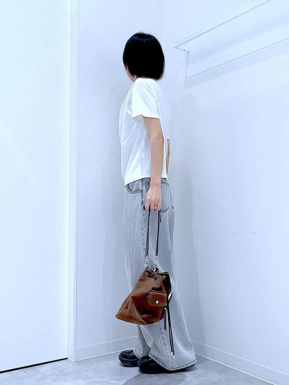 ブラック系のローファー、ブラウン系のショルダーバッグ、ホワイト系のTシャツ/カットソーを着用したレディースの秋コーディネートの3枚目の写真