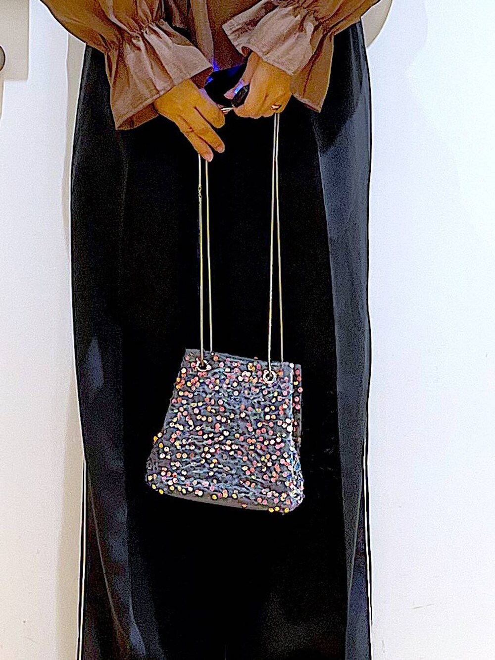 グレー系のショルダーバッグ、ブラック系のスラックス、ブラック系のパンプスを着用したレディースの秋コーディネートの9枚目の写真