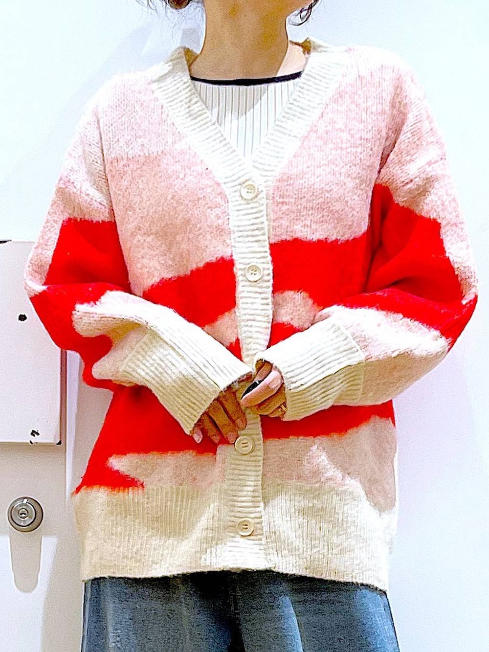 ベージュ系のブーツ、ベージュ系のニット/セーター、ブルー系のデニムパンツを着用したレディースの冬コーディネートの7枚目の写真