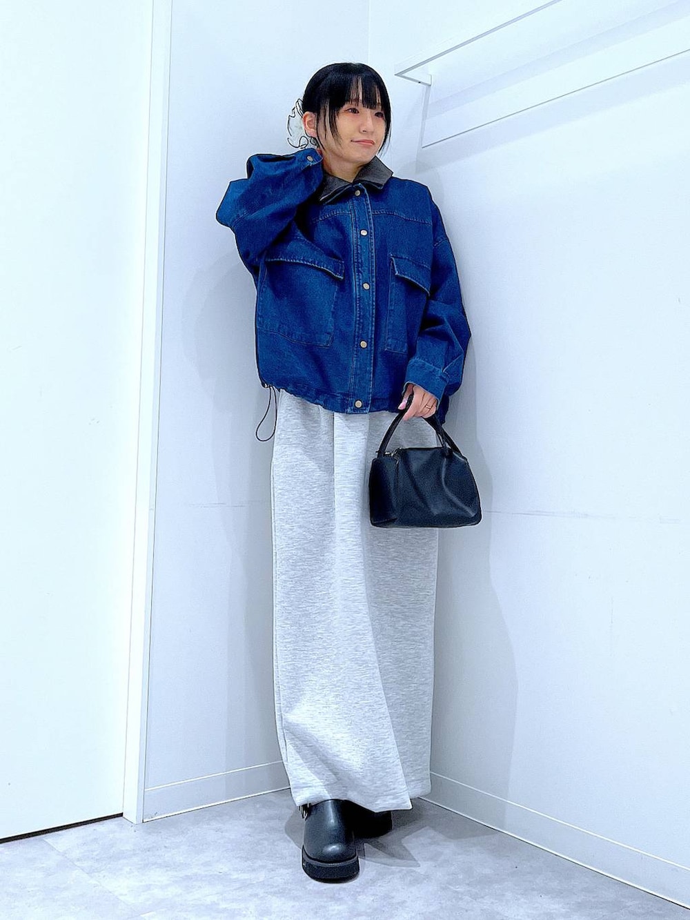 ブラック系のショルダーバッグ、グレー系のスカート、ブラック系のサンダルを着用したレディースの春コーディネートの2枚目の写真