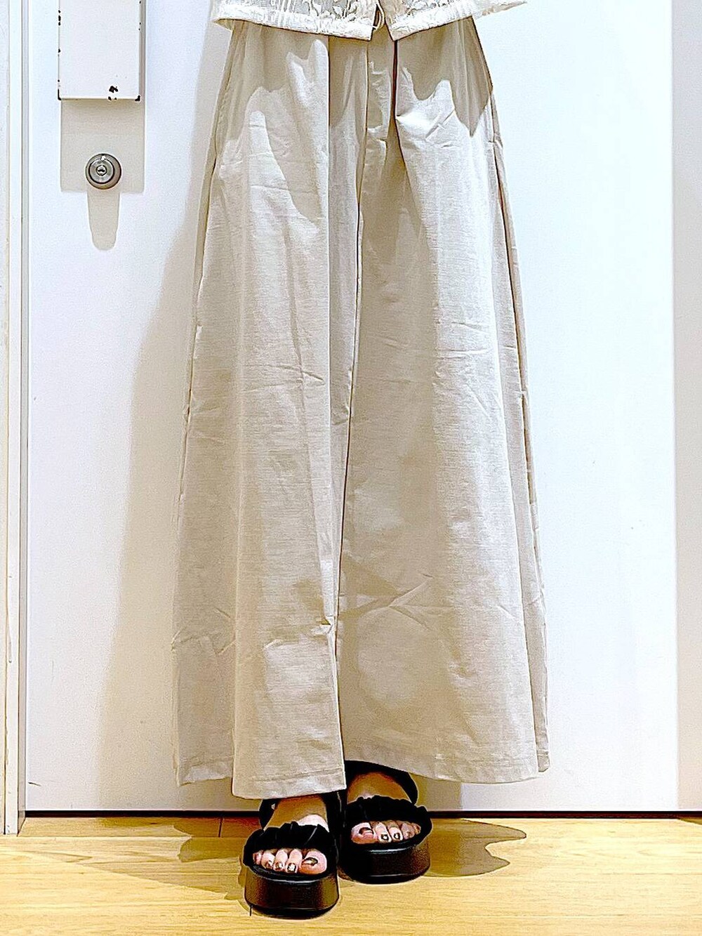 ブラック系のサンダル、ベージュ系のシャツ/ブラウス、ベージュ系のスカートを着用したレディースの夏コーディネートの8枚目の写真