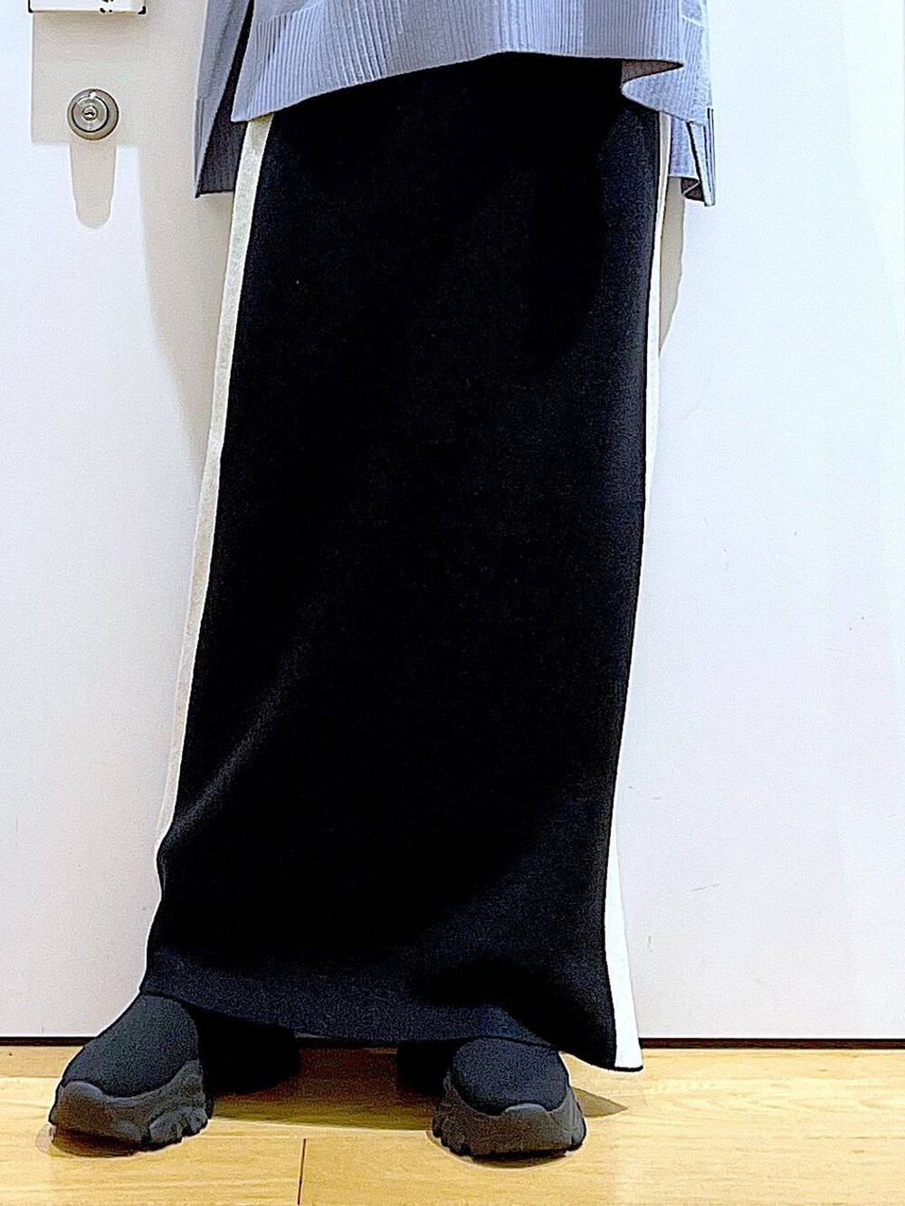 ブラック系のスカート、ブラック系のショルダーバッグ、ブラック系のブーツを着用したレディースの冬コーディネートの8枚目の写真