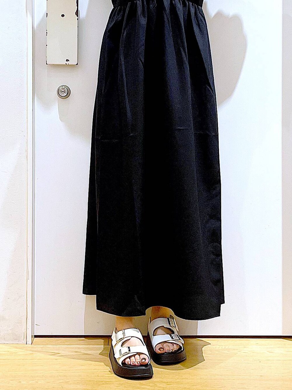 ホワイト系のサンダル、グレー系のトートバッグ、ブラック系のワンピースを着用したレディースの夏コーディネートの8枚目の写真