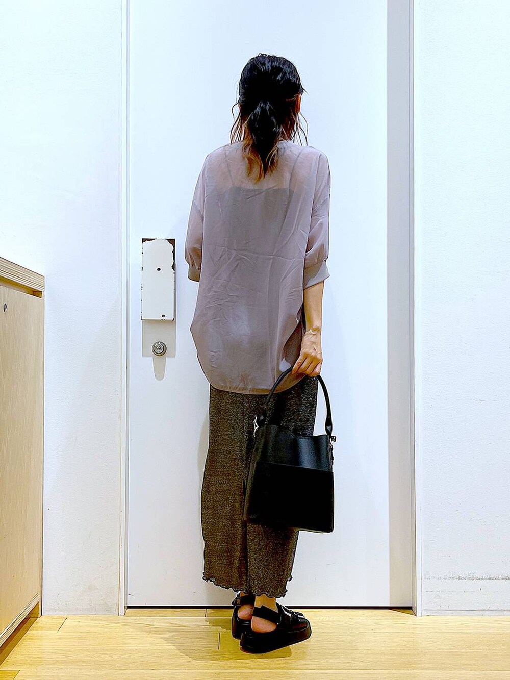 ブラック系のスカート、ブラック系のショルダーバッグ、ブラック系のサンダルを着用したレディースの夏コーディネートの5枚目の写真