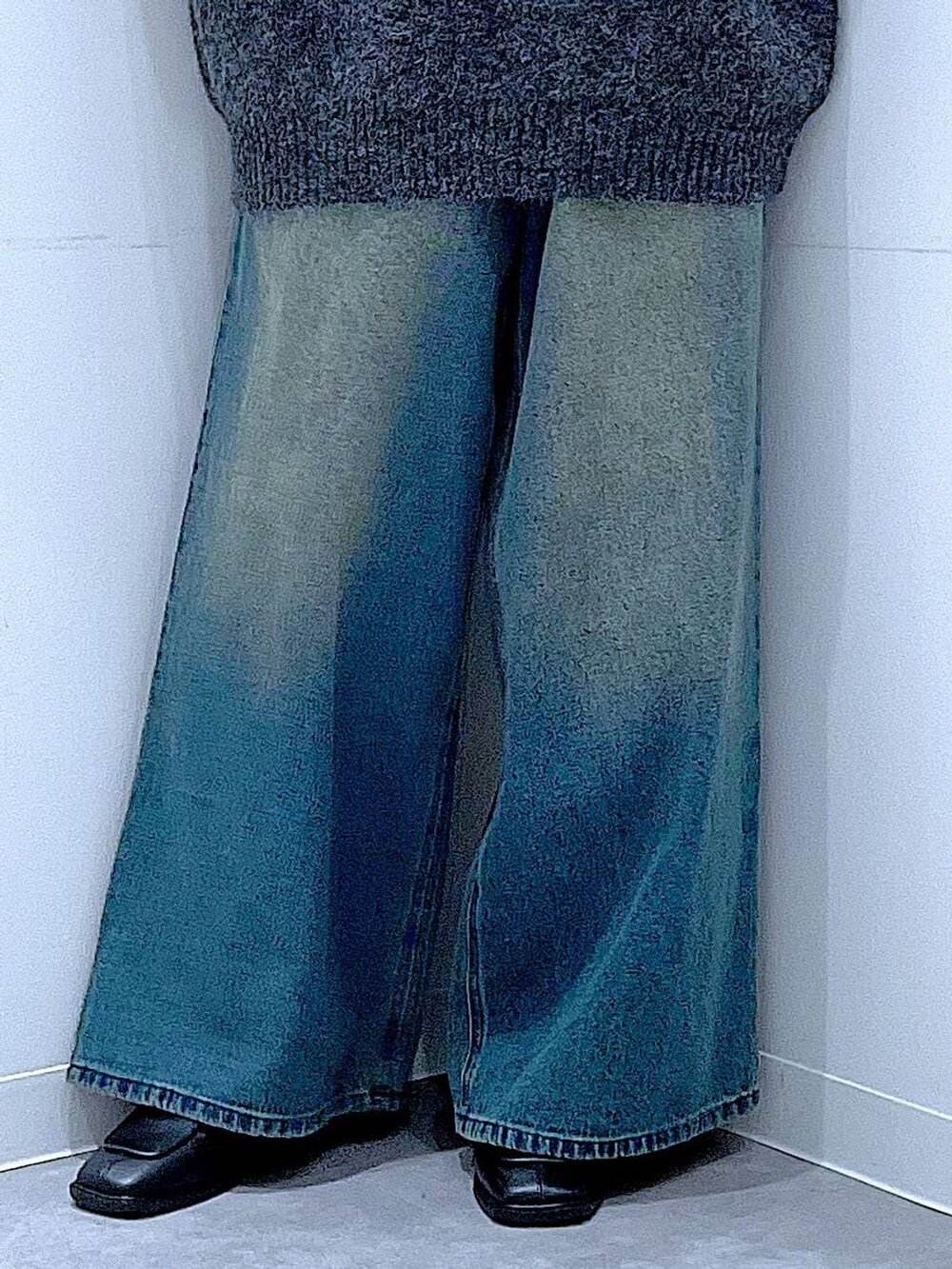 ブラウン系のショルダーバッグ、ブルー系のデニムパンツ、ブラック系のブーツを着用したレディースの冬コーディネートの8枚目の写真