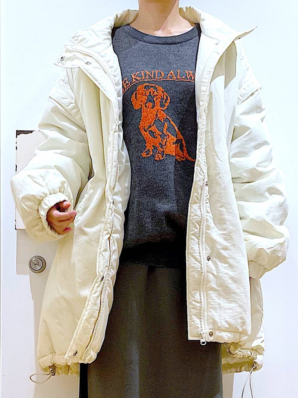 グレー系のスカート、ブラック系のブーツ、ホワイト系のその他アウターを着用したレディースの冬コーディネートの7枚目の写真