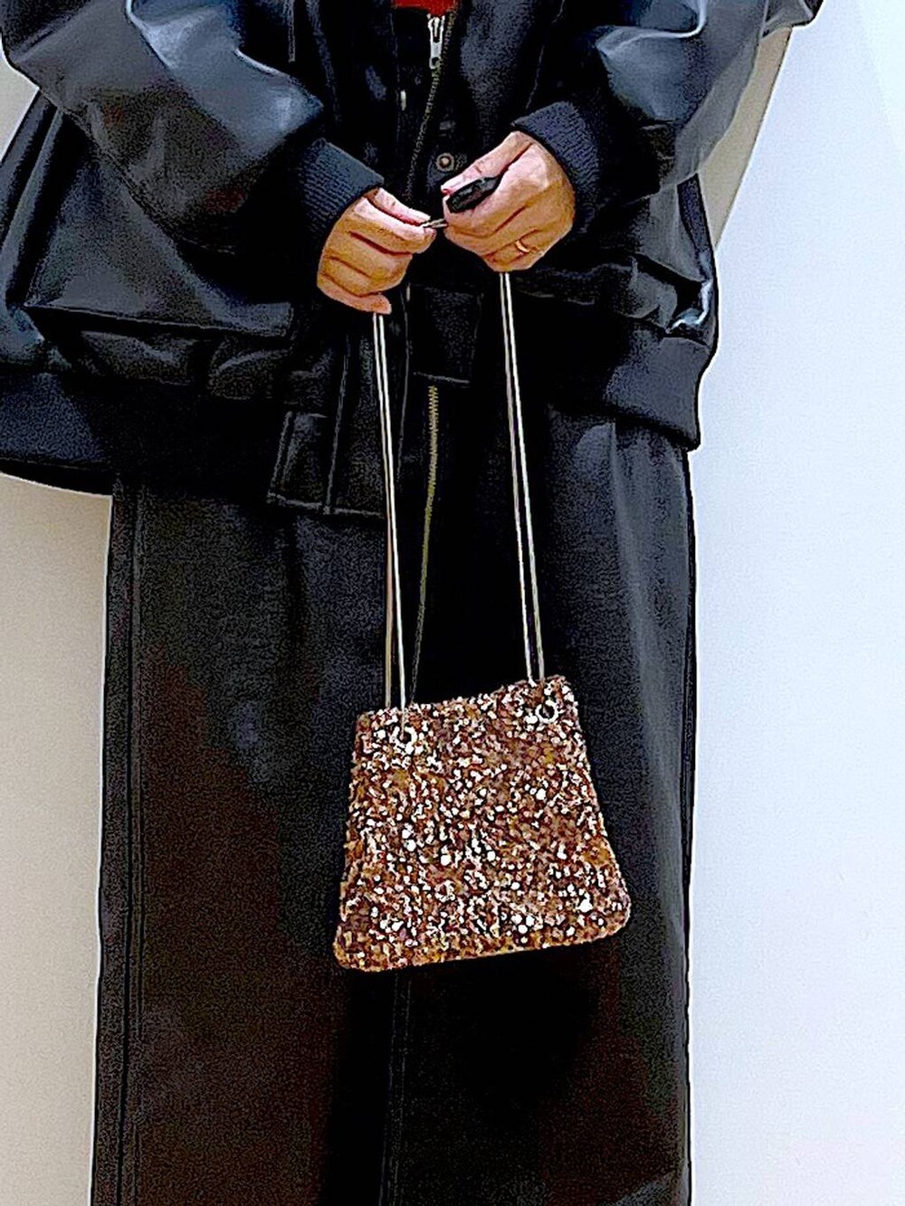 オレンジ系のニット/セーター、ブラウン系のスカート、ブラック系のブーツを着用したレディースの冬コーディネートの9枚目の写真