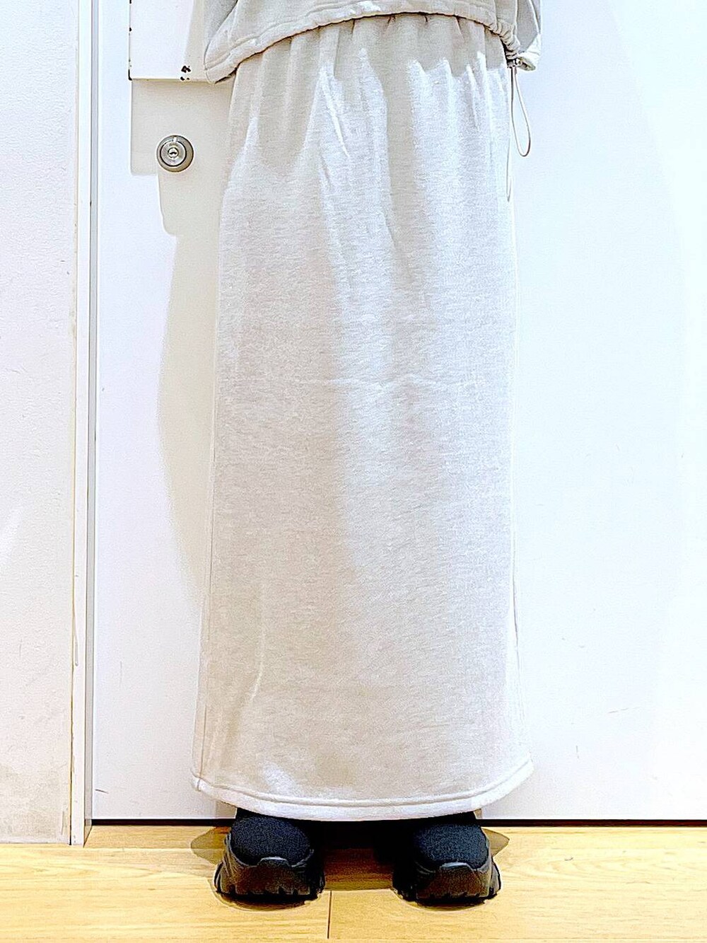 ブラック系のブーツ、ブラック系のショルダーバッグ、ベージュ系のスウェットを着用したレディースの冬コーディネートの8枚目の写真