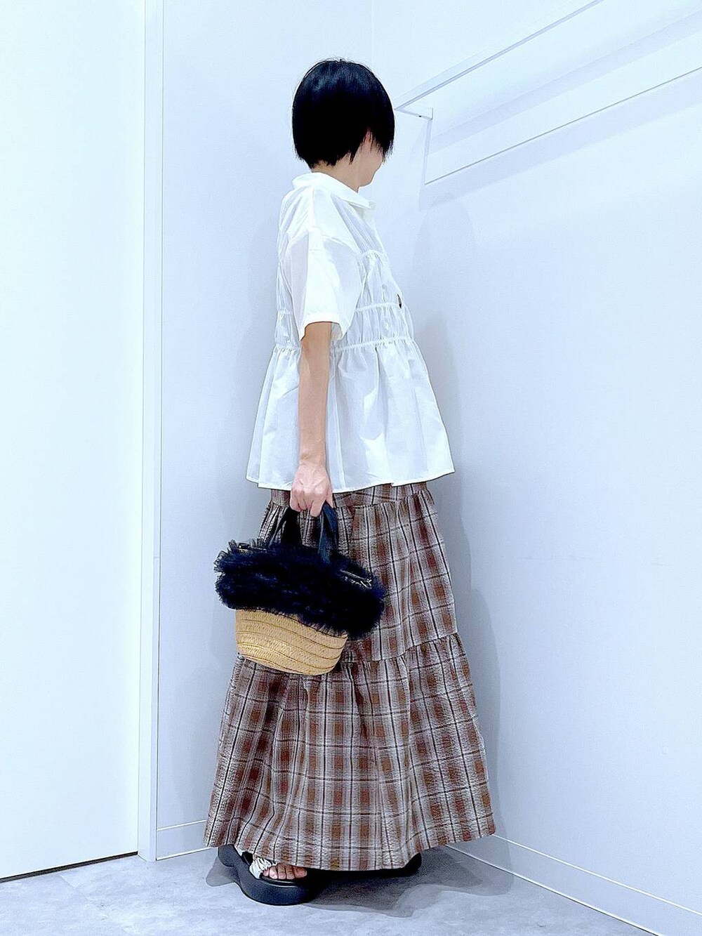 ベージュ系のショルダーバッグ、シルバー系のサンダル、ブラウン系のワンピースを着用したレディースの夏コーディネートの4枚目の写真