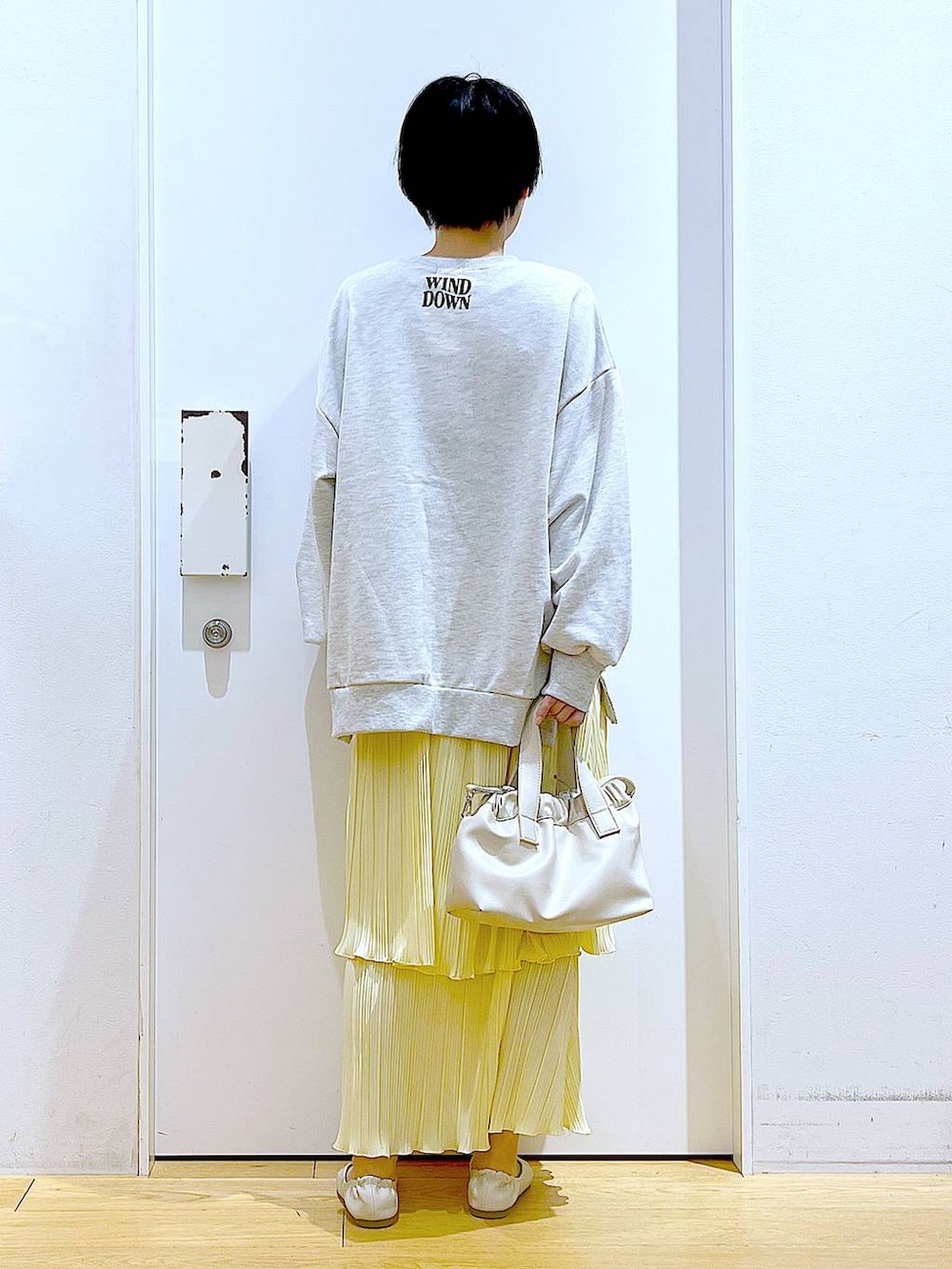 ホワイト系のショルダーバッグ、ホワイト系のパンプス、ベージュ系のスウェットを着用したレディースの冬コーディネートの5枚目の写真