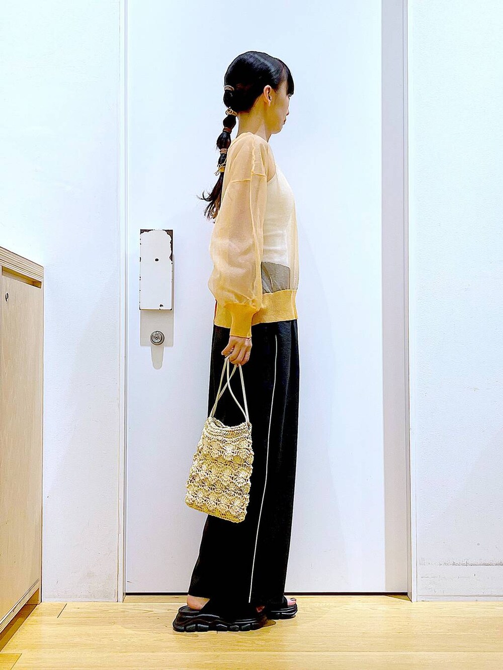 ブラック系のサンダル、オレンジ系のカーディガン/ボレロ、ベージュ系のショルダーバッグを着用したレディースの夏コーディネートの4枚目の写真