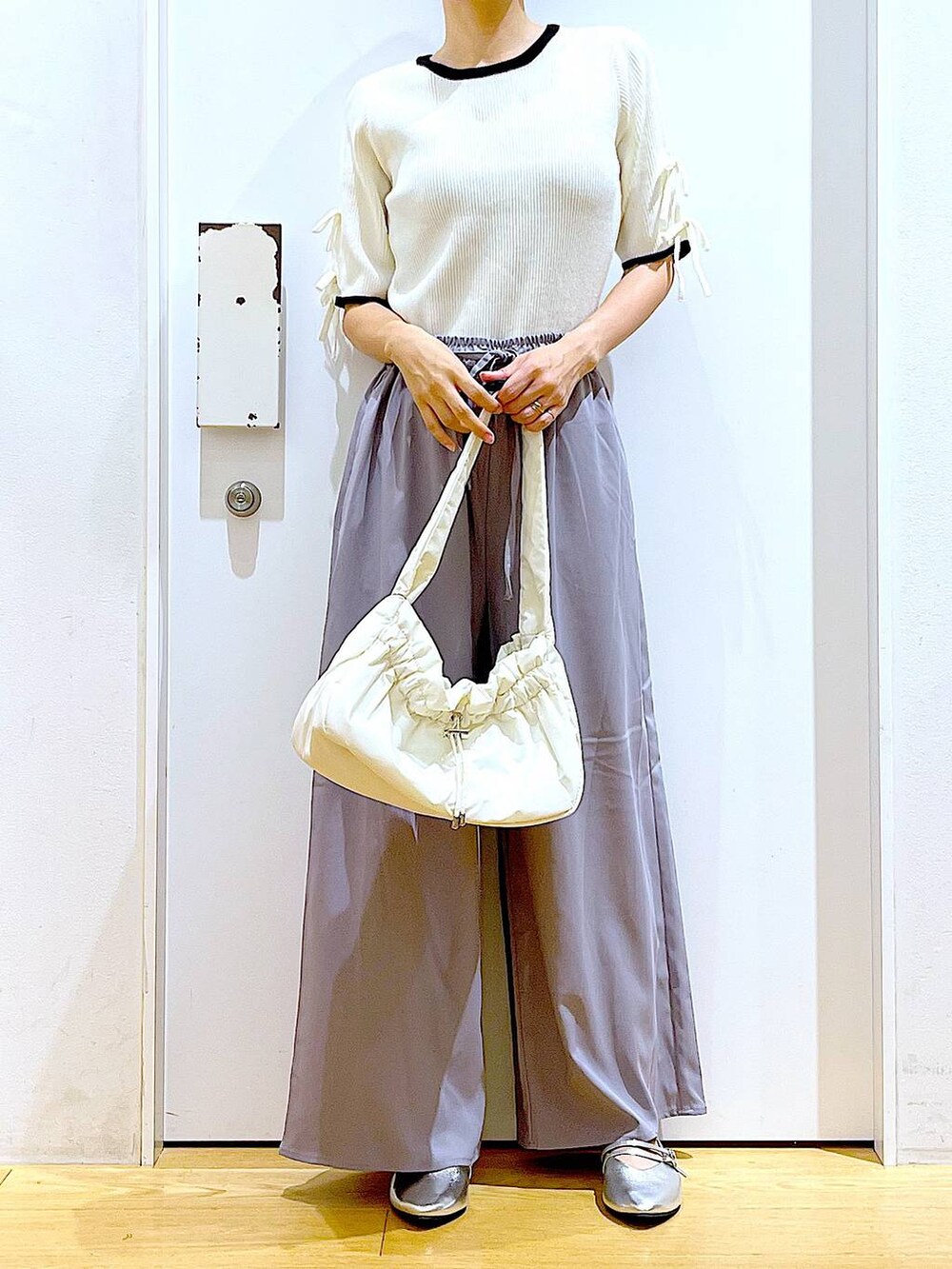 ホワイト系のハンドバッグ、グレー系のその他パンツ、シルバー系のパンプスを着用したレディースの秋コーディネートの6枚目の写真