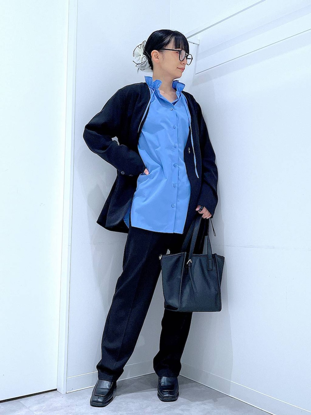 ブラック系のブーツ、ブラック系のトートバッグ、ブラック系のノーカラージャケットを着用したレディースの冬コーディネートの2枚目の写真