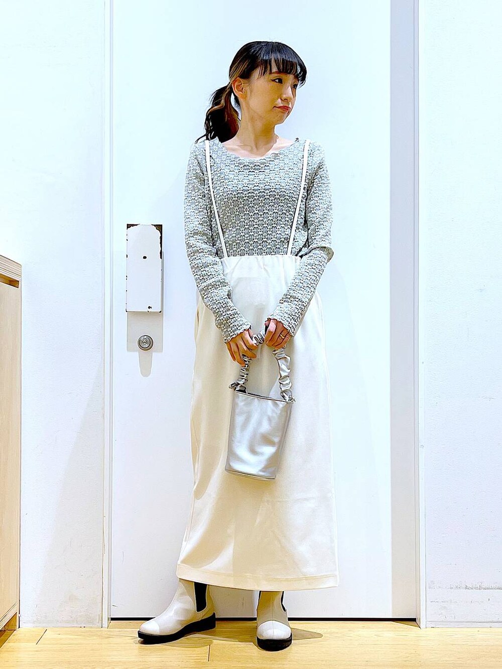 その他のショルダーバッグ、ベージュ系のブーツ、ホワイト系のスカートを着用したレディースの春コーディネートの2枚目の写真