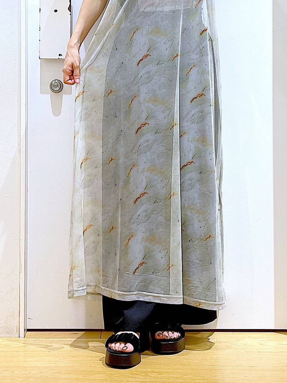 ブラック系のサンダル、ブラック系のトートバッグ、ベージュ系のワンピースを着用したレディースの夏コーディネートの8枚目の写真