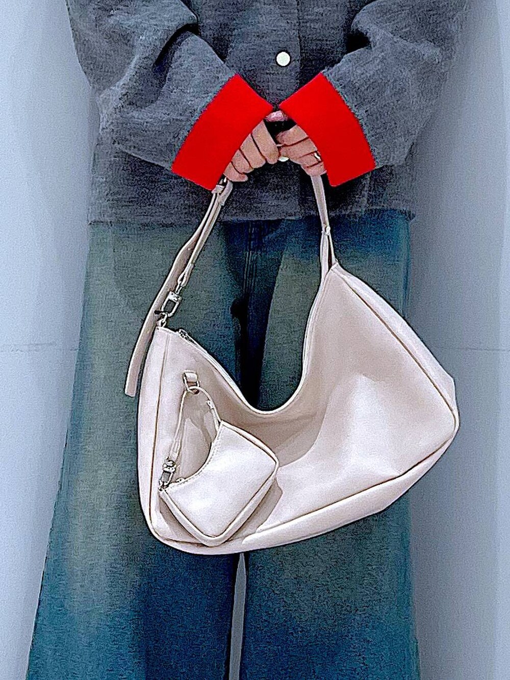 ブルー系のデニムパンツ、ブラック系のブーツ、ホワイト系のショルダーバッグを着用したレディースの冬コーディネートの9枚目の写真