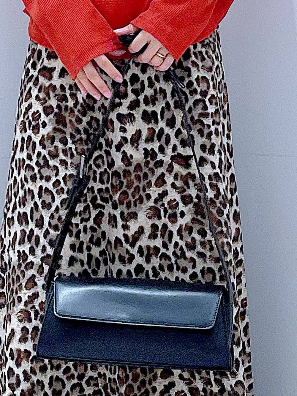 ブラック系のショルダーバッグ、ブラウン系のブーツ、ブラウン系のスカートを着用したレディースの秋コーディネートの9枚目の写真