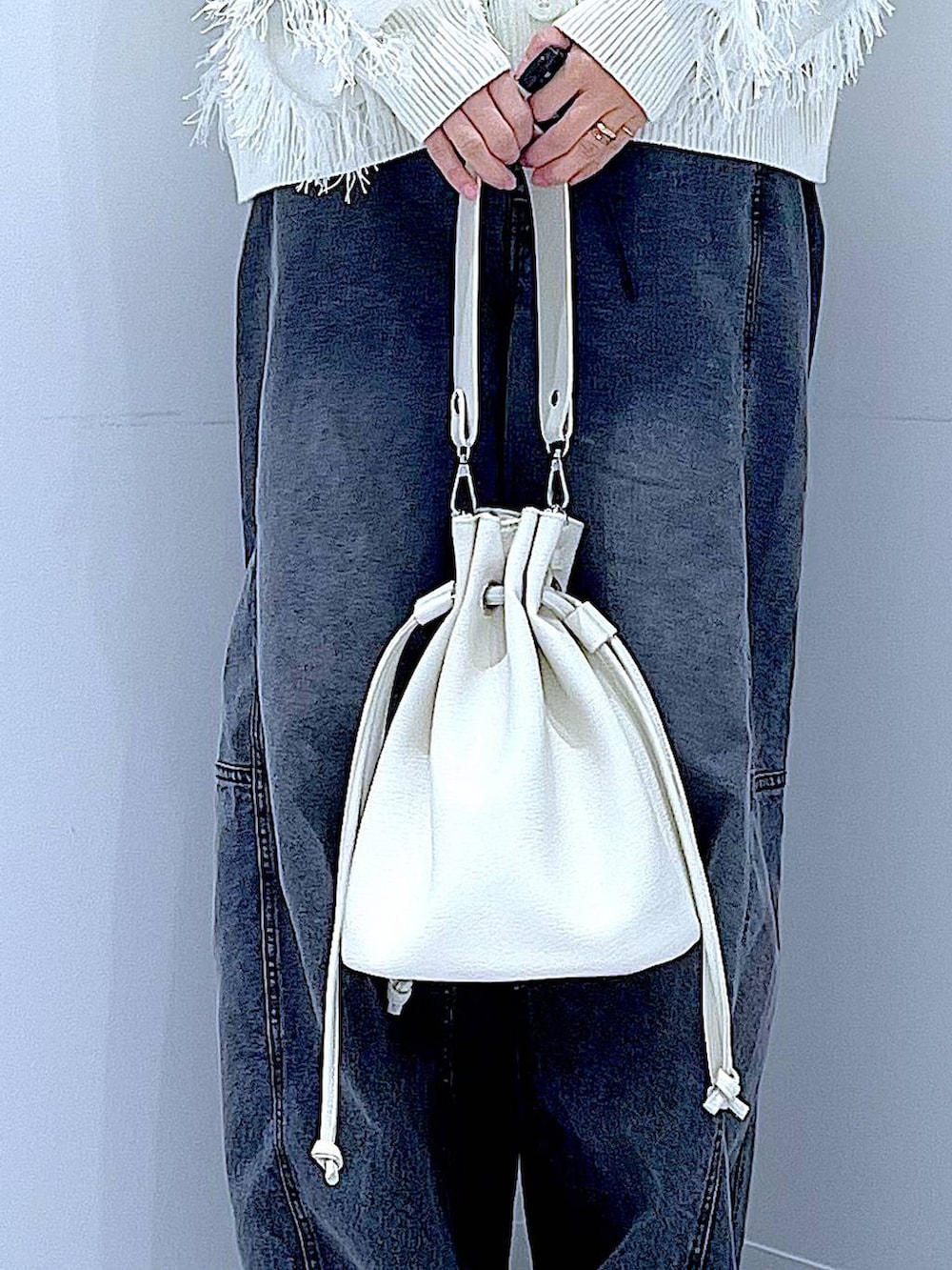 ブラック系のTシャツ/カットソー、ブラック系のデニムパンツ、ホワイト系のショルダーバッグを着用したレディースの春コーディネートの9枚目の写真