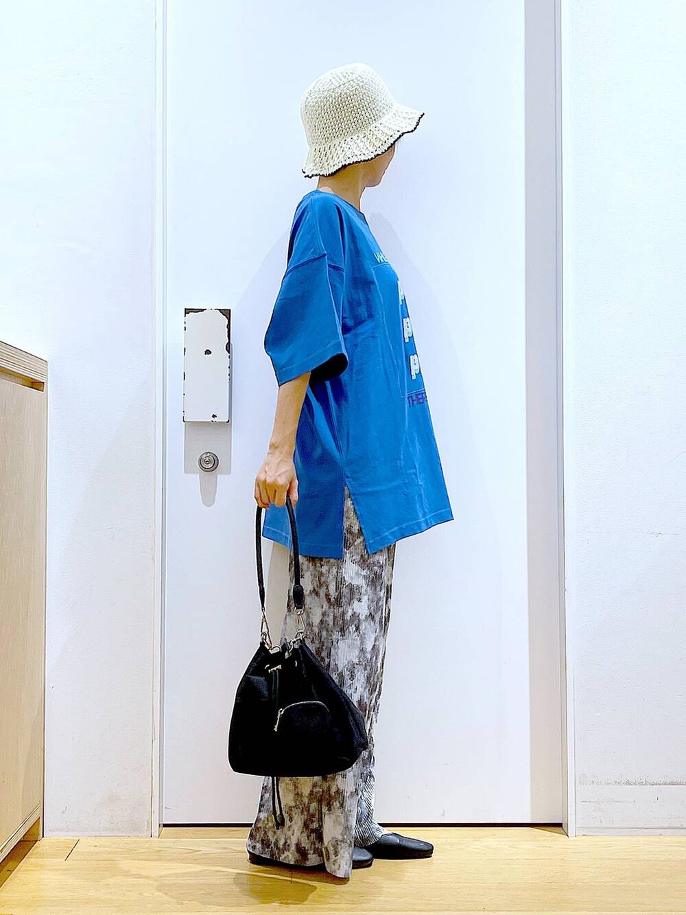 ブラック系のパンプス、グレー系のその他パンツ、ブルー系のTシャツ/カットソーを着用したレディースの春コーディネートの4枚目の写真