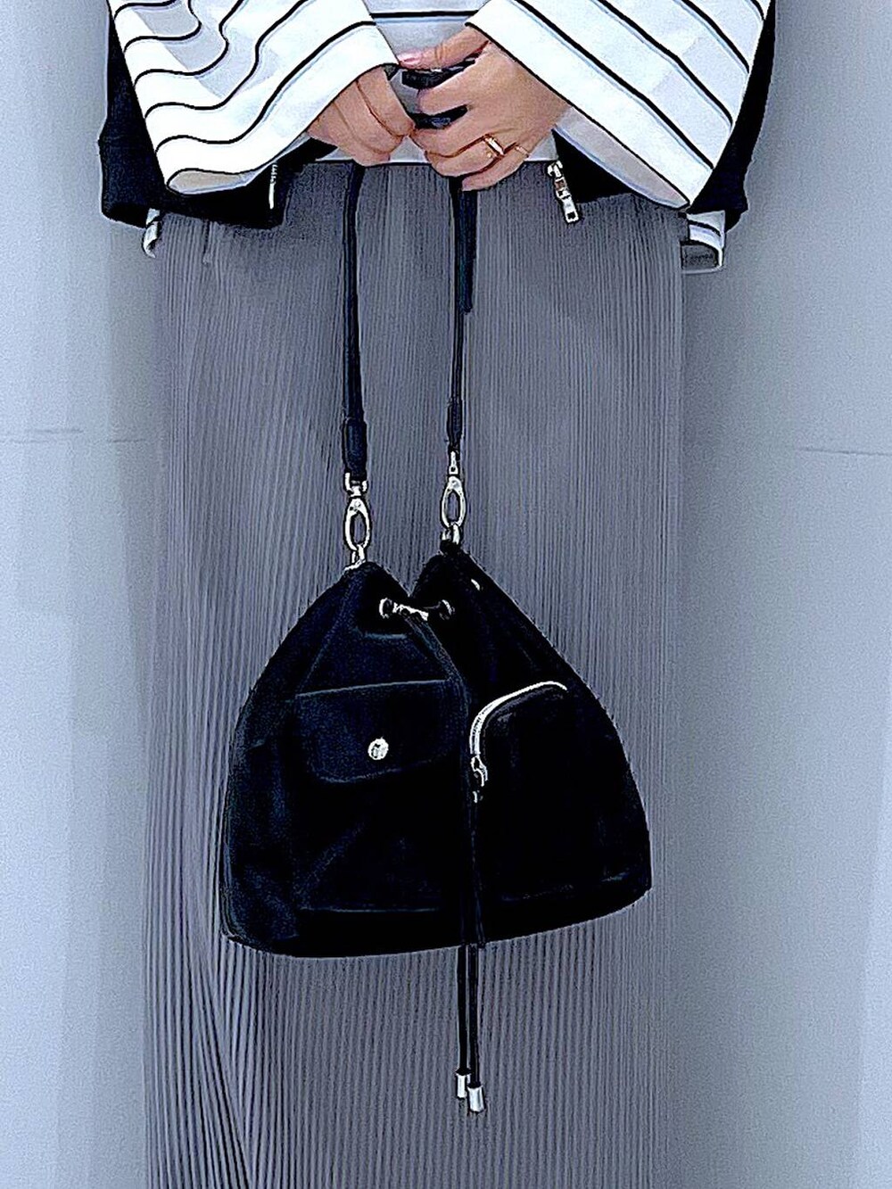 ブラック系のショルダーバッグ、ホワイト系のTシャツ/カットソー、グレー系のスカートを着用したレディースの春コーディネートの9枚目の写真