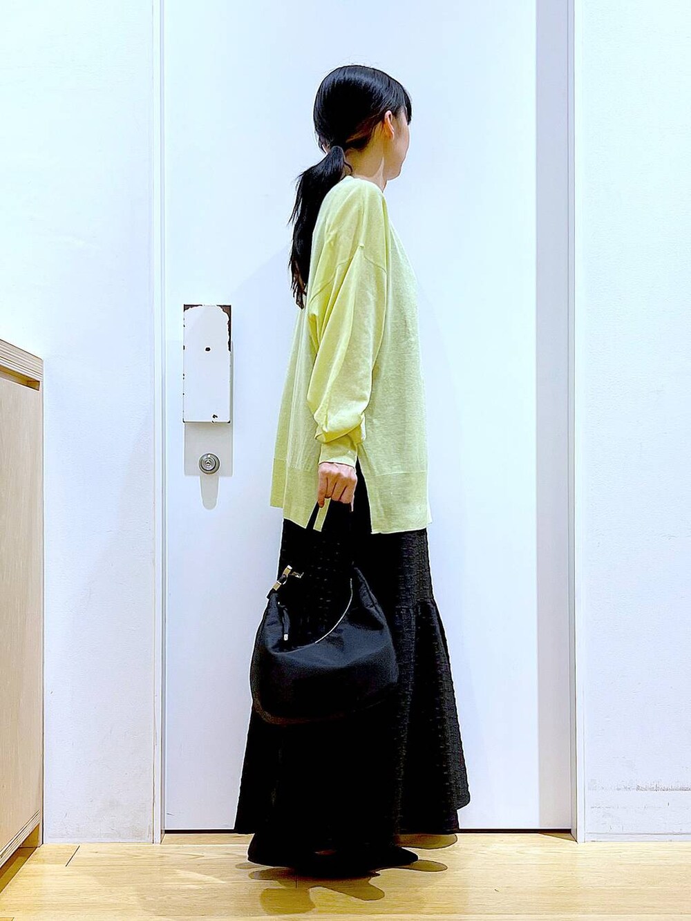ブラック系のワンピース、グリーン系のカーディガン/ボレロ、ブラック系のショルダーバッグを着用したレディースの春コーディネートの4枚目の写真