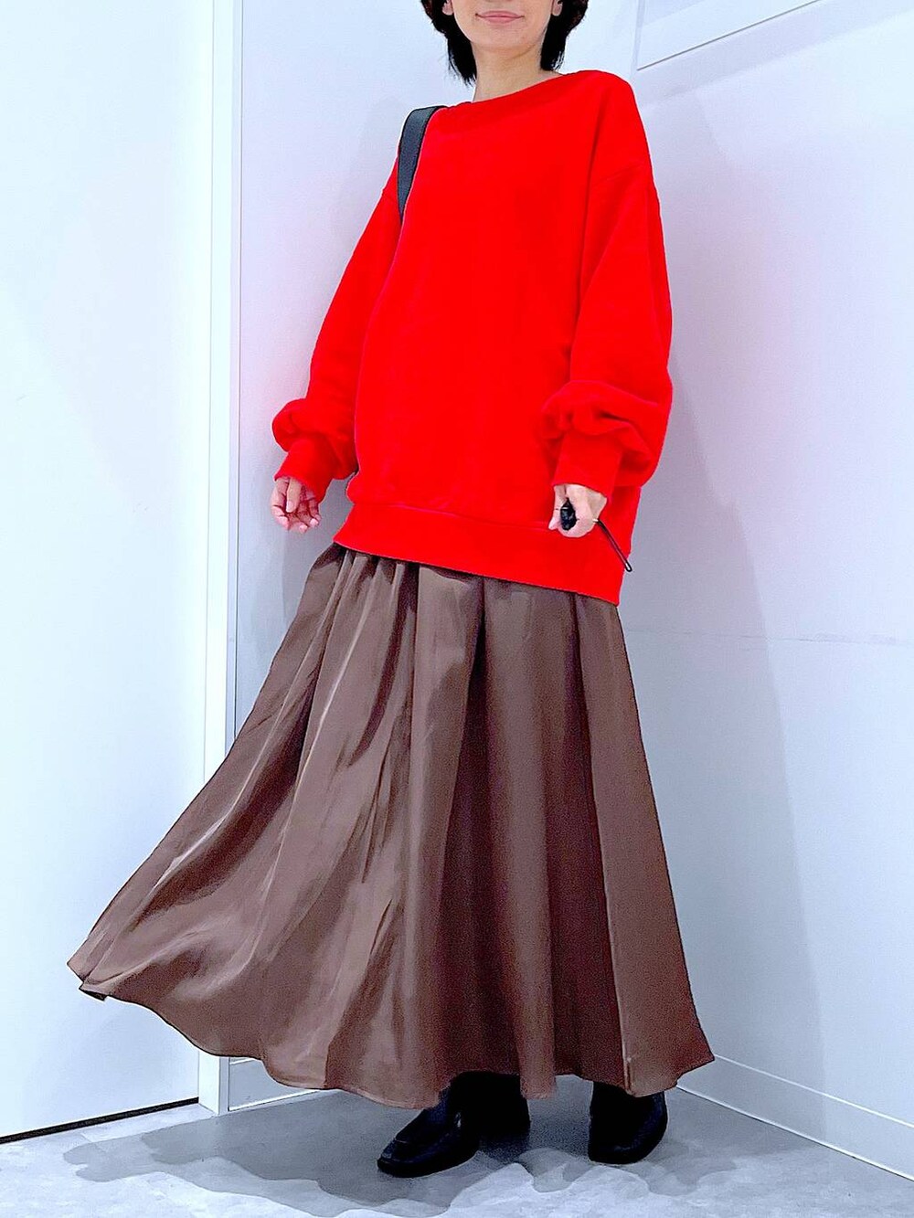 ブラック系のショルダーバッグ、ブラック系のブーツ、レッド系のスウェットを着用したレディースの秋コーディネートの6枚目の写真