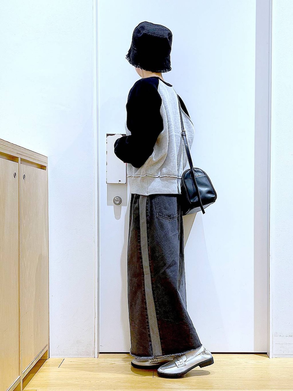 シルバー系のローファー、ブラック系のニット/セーター、ブラック系のショルダーバッグを着用したレディースの冬コーディネートの3枚目の写真